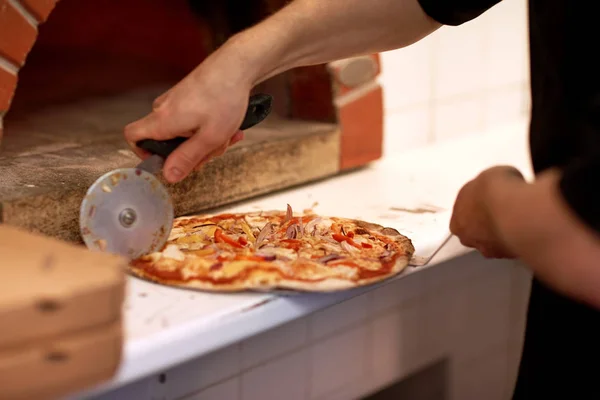 Kesme pizza pizzacı, parçalara el yemek — Stok fotoğraf