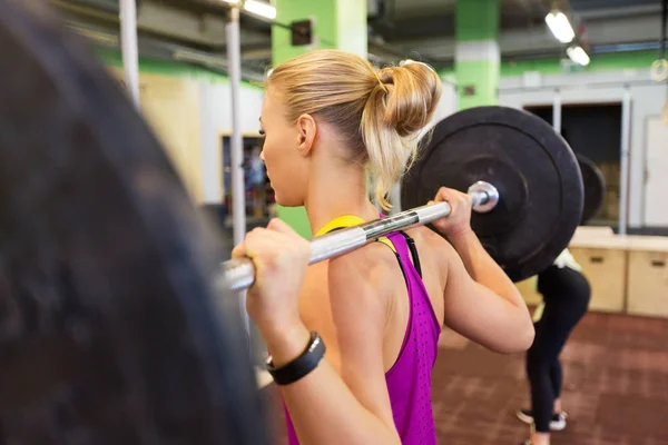 Donna con bilanciere all'allenamento di gruppo in palestra — Foto Stock