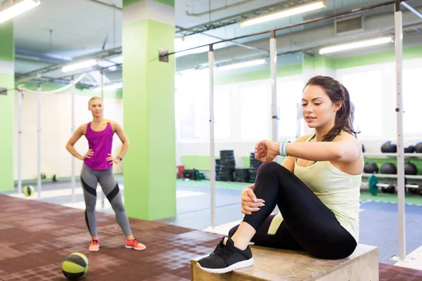 Femmes avec tracker fitness et ballon dans la salle de gym — Photo