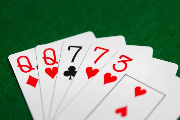 Mão de poker de jogar cartas no pano de casino verde — Fotografia de Stock