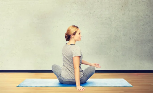 Woman making yoga in twist pose on mat — Stock Photo, Image