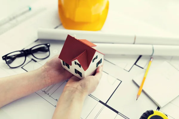 Close up of hands with house model above blueprint — Stock Photo, Image