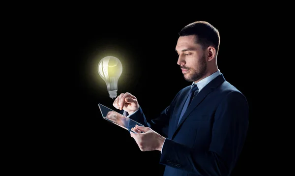 Affärsman med TabletPC och glödlampa — Stockfoto