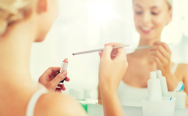 Woman with lipstick and make up brush at bathroom — Stock Photo, Image