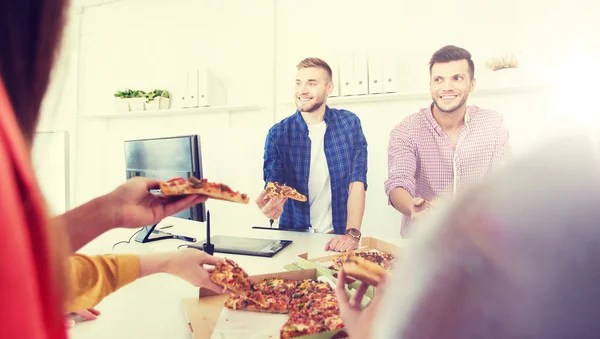 Счастливая команда бизнесменов ест пиццу в офисе — стоковое фото