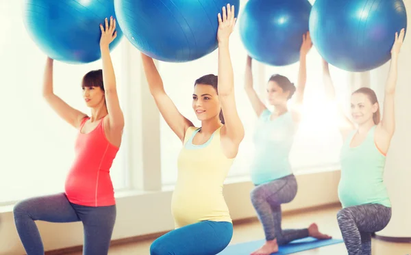 Mujeres embarazadas felices haciendo ejercicio con pelota en el gimnasio —  Fotos de Stock