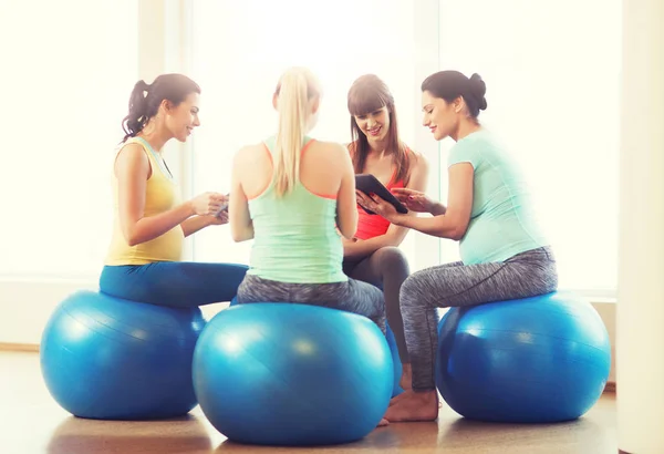 Happy pregnant women with gadgets in gym — Stock Photo, Image