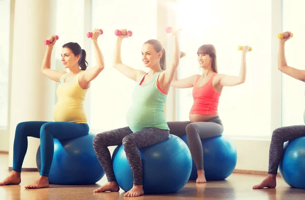 Mujeres embarazadas felices haciendo ejercicio en fitball en el gimnasio —  Fotos de Stock