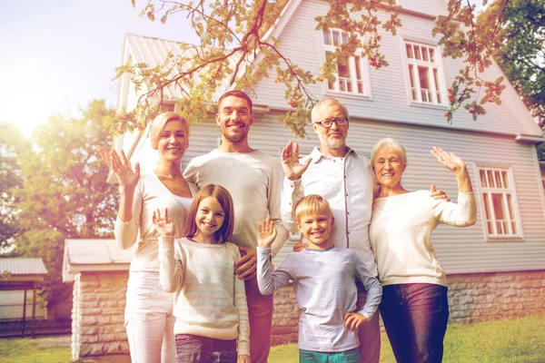 Família feliz na frente da casa ao ar livre — Fotografia de Stock