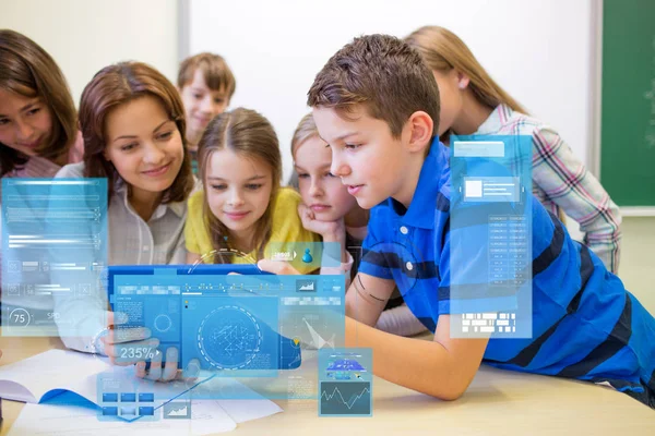 Groep van jonge geitjes met leraar en tablet pc op school — Stockfoto