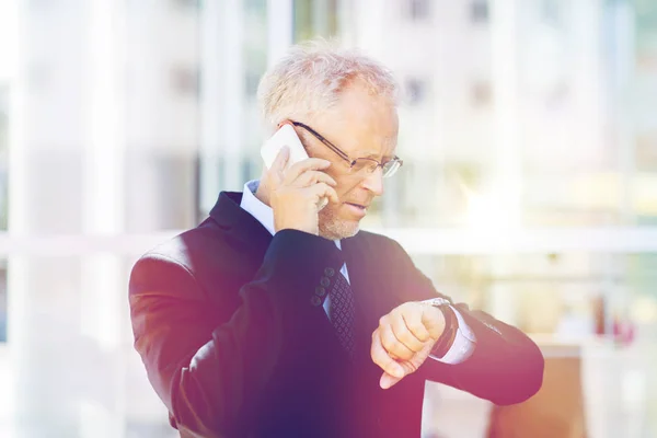 Hombre de negocios senior que llama en el teléfono inteligente en la ciudad — Foto de Stock