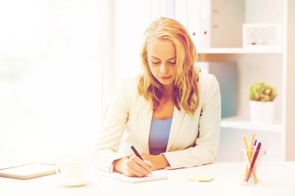 Bizneswoman pisząc do notebooka w biurze — Zdjęcie stockowe