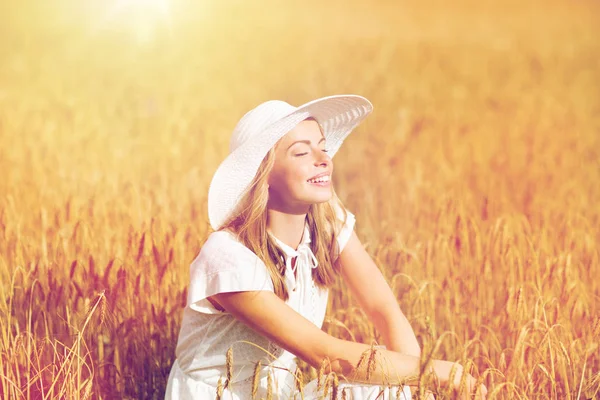 Glückliche junge Frau mit Sonnenhut auf einem Getreidefeld — Stockfoto