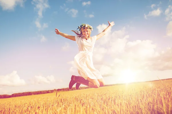 Gelukkige vrouw in krans springen op granen veld — Stockfoto