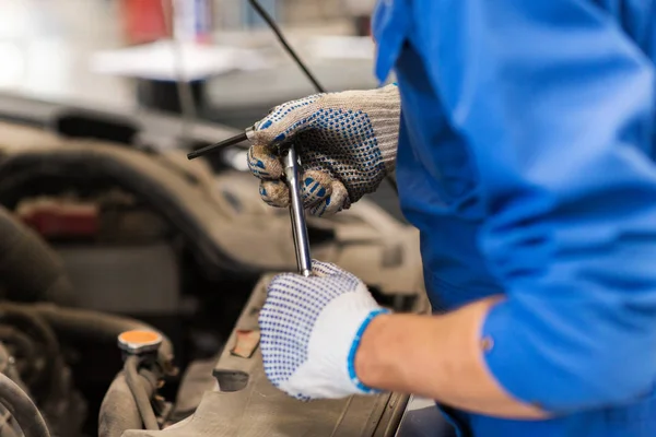 Mekaniker man med skiftnyckel reparera bil på verkstaden — Stockfoto