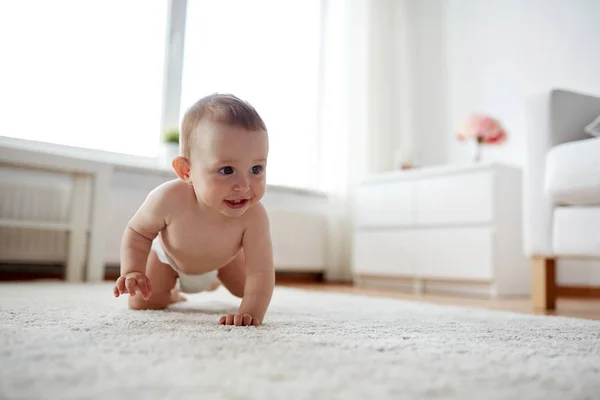 Pequeno bebê em fralda rastejando no chão em casa — Fotografia de Stock