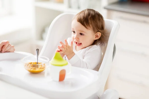 Niña feliz con comida y bebida comiendo en casa — Foto de Stock