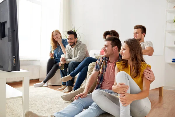 Amigos felices con palomitas de maíz viendo la televisión en casa — Foto de Stock