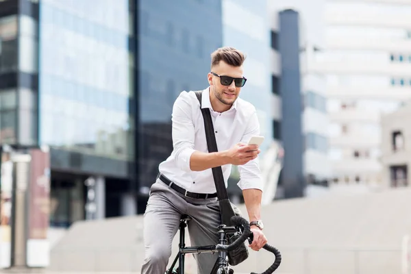 Hombre con bicicleta y teléfono inteligente en la calle de la ciudad — Foto de Stock