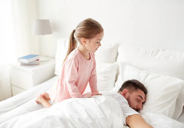 Küçük kız yatakta uyuyan babası uyanma — Stok fotoğraf