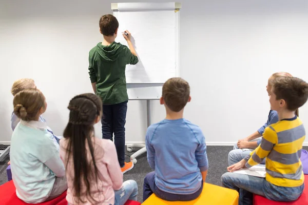 Estudiante chico con marcador escritura en flip board — Foto de Stock