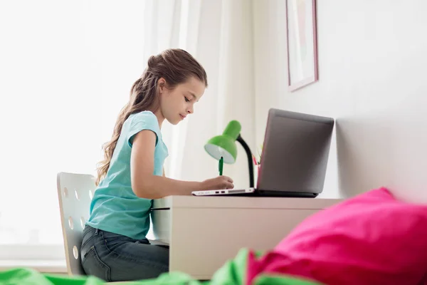 Chica con la escritura del ordenador portátil a la libreta en casa — Foto de Stock