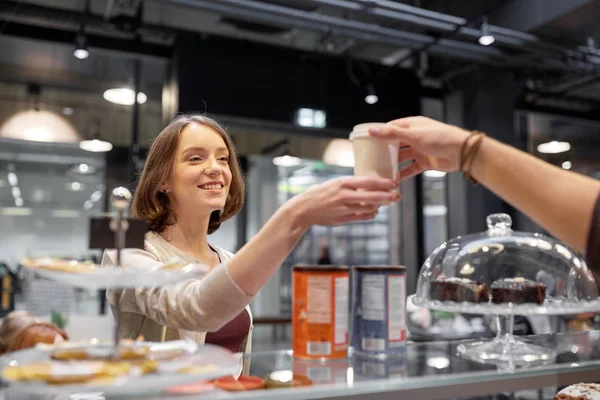 Mujer feliz tomando taza de café del vendedor en la cafetería —  Fotos de Stock