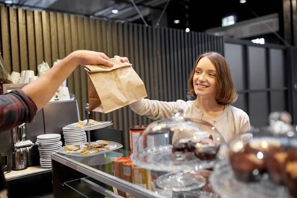 Nő vesz papírzacskót eladótól a kávézóban — Stock Fotó