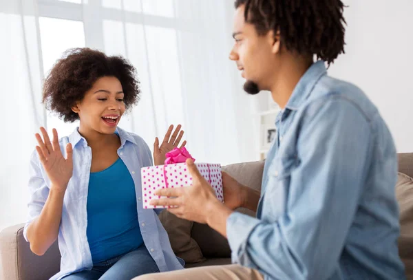 Casal feliz com caixa de presente em casa — Fotografia de Stock