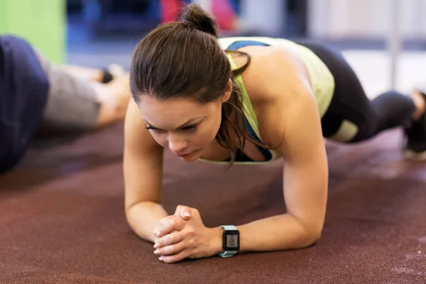 Mulher com rastreador de ritmo cardíaco se exercitando no ginásio — Fotografia de Stock