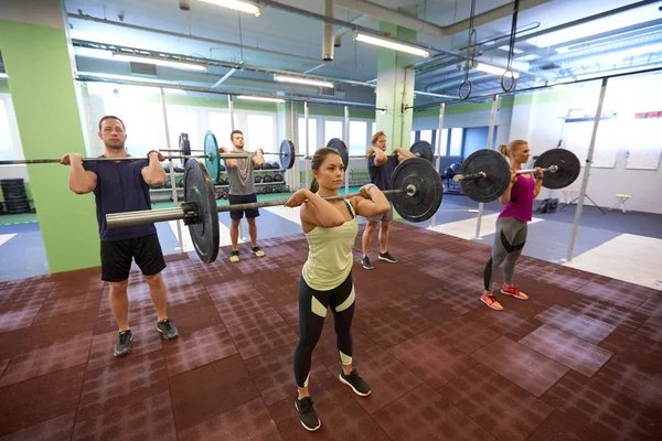 Träningsgrupp med skivstång och vikter på gym — Stockfoto