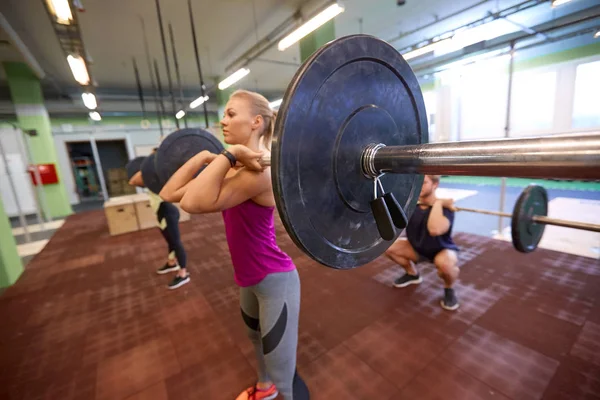 Grupo de personas entrenando con pesas en el gimnasio — Foto de Stock