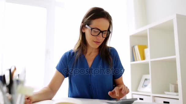 Женщина с калькулятором и ноутбуком в офисе — стоковое видео