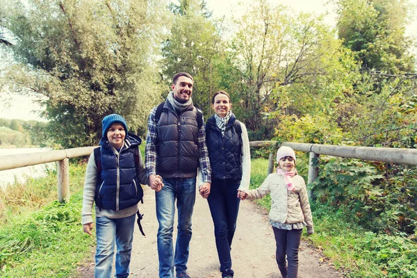 Gelukkige familie met rugzakken wandelen in de bossen — Stockfoto