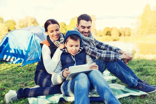 Famiglia felice con tablet pc e tenda nel campeggio — Foto Stock