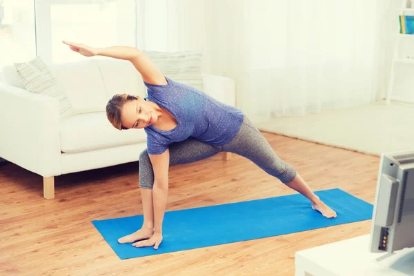 Женщина делает yoga треугольник bikram поза на циновке — стоковое фото