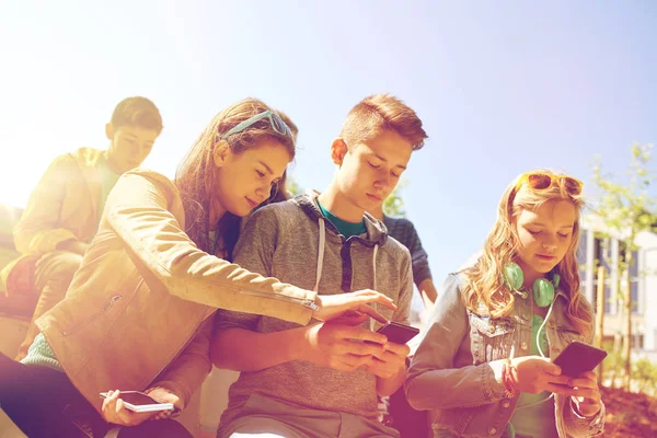 Amigos adolescentes con smartphone y auriculares — Foto de Stock