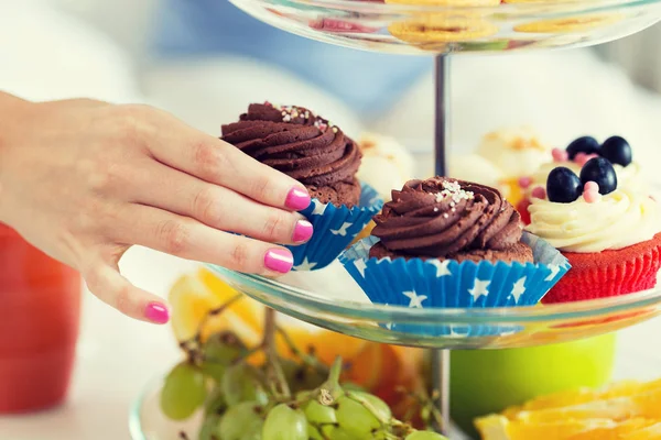 Primer plano de la mano tomando cupcake de pie de la torta — Foto de Stock