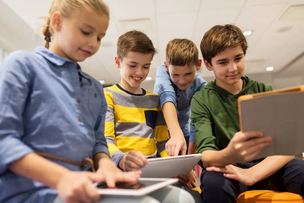 Grupo de crianças felizes com tablet pc na escola — Fotografia de Stock