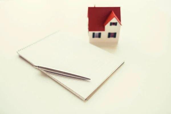 Close up of house model, notebook and pencil — Stock Photo, Image