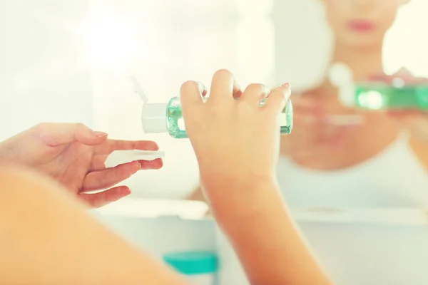 Young woman with lotion washing face at bathroom — Stock Photo, Image