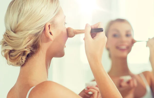 Vrouw met make-up borstel en poeder op de badkamer — Stockfoto