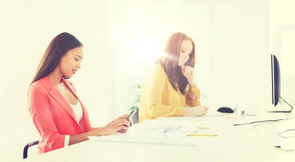 Business woman texting on smartphone at office — стоковое фото