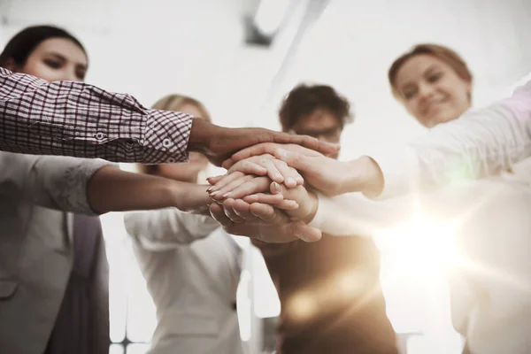 Feliz equipo de negocios con las manos en la parte superior en la oficina —  Fotos de Stock