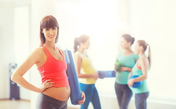 Happy pregnant woman with mat in gym — Stock Photo, Image