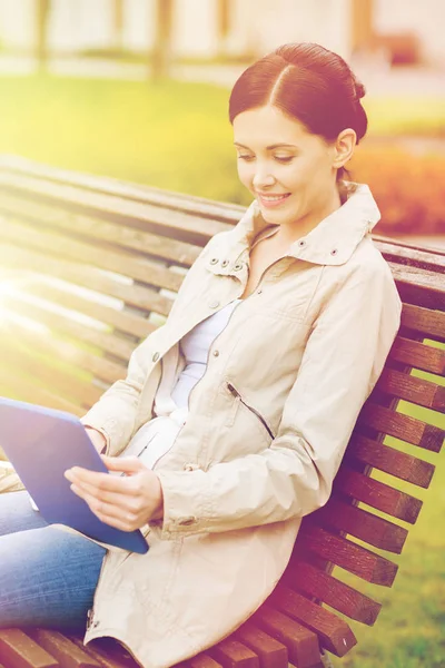 Mulher com tablet pc sentado no banco no parque — Fotografia de Stock