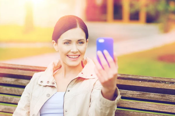 Femme souriante prenant des photos avec smartphone — Photo