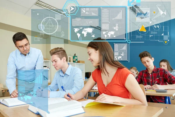 Teacher helping students with task at school — Stock Photo, Image