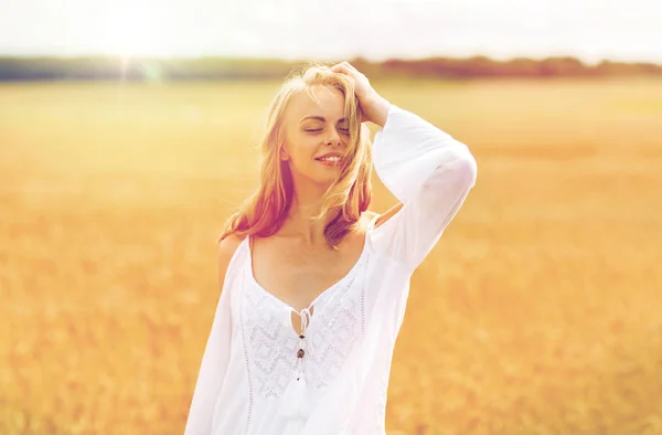 Sorrindo jovem mulher em vestido branco no campo de cereais — Fotografia de Stock