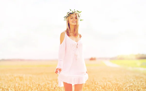 Szczęśliwa młoda kobieta w wieńcu kwiatowym na polu zbożowym — Zdjęcie stockowe
